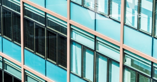 A modern commercial building with energy-efficient glass windows reflecting sunlight and enhancing sustainability.